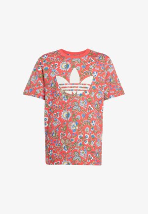 Floral-patterned red cotton t-shirt featuring an oversized white Adidas logo in the center, short sleeves, and a round neckline.