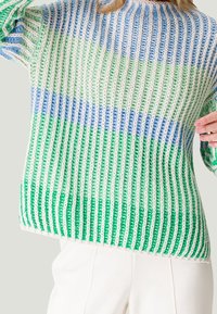 Häkelpullover mit vertikalen Streifen in Grün, Blau und Weiß. Das lockere Maschenbild sorgt für eine atmungsaktive Textur und einen entspannten Sitz.