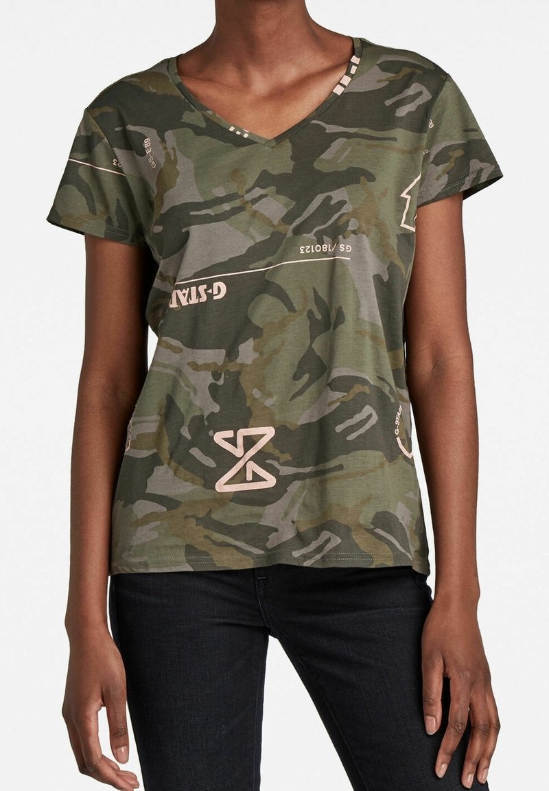 Zelené maskáčové tričko s výstřihem do V a krátkými rukávy, s jemně růžovým grafickým textem a designem, a volným střihem z měkké tkaniny.