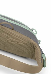 Bolso gris y beige con detalles en verde menta. Tejido texturizado, cierre de cremallera y correa ajustable. El interior incluye detalles de bolsillo cosidos.