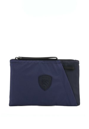 Bustina blu navy con cerniera, rifinitura nera, anello in tessuto ed emblema a scudo in rilievo al centro davanti.