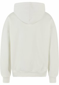 Hoodie blanc en tissu doux, avec une capuche arrondie, des poignets côtelés et un ourlet légèrement élastiqué. Texture lisse et design minimal.