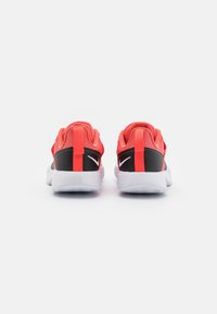 Nike träningsskor med en ljus korallig nätöverdela, svarta detaljer, vit sula och en framträdande hälflik för enkel påtagning.