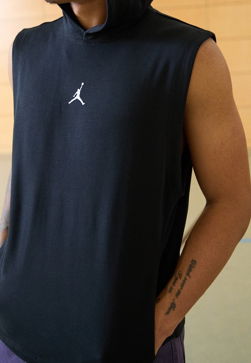 Hoodie senza maniche nero in cotone, con logo Jordan bianco sul petto. Fessure laterali per facilitare il movimento e vestibilità casual.