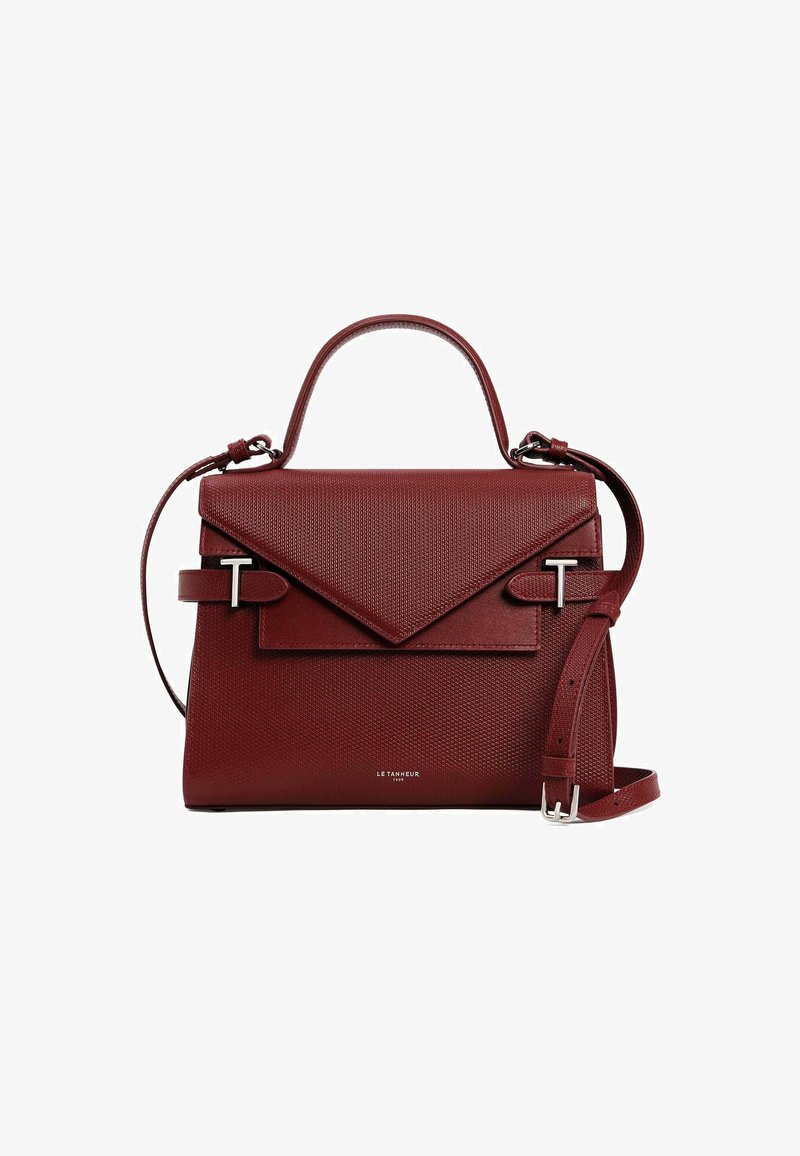 Red textured handbag with a structured design, featuring a top handle, adjustable strap, and a flap closure with a decorative metal accent.