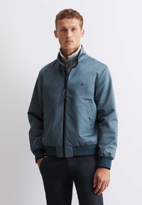 Light blue bomber jacket made of smooth fabric, featuring a zip closure, ribbed cuffs, two side pockets, and a small logo on the chest.