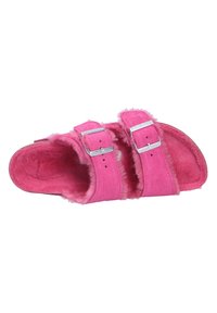 Furry pink slide sandal featuring two silver metal buckles, soft suede material, textured insole, and rounded open toe design.