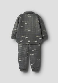 Pigiama grigio trapuntato con stampe di elicotteri, composto da una giacca a pullover e pantaloni con cintura elastica, dettagliati con polsini a coste.