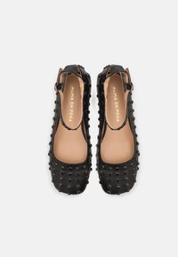 Ballerines Mary Jane en cuir noir avec clous ronds, bouts carrés et sangles à boucle à la cheville, semelles intérieures marquées "Alma en Pena".
