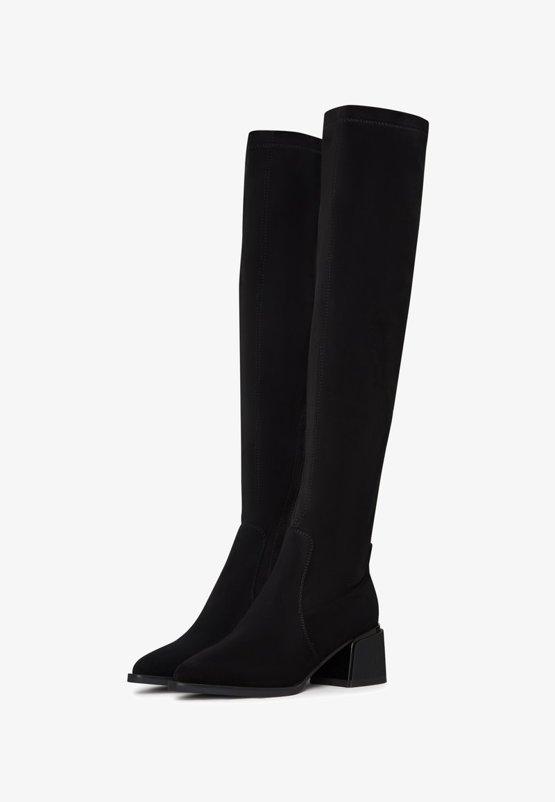 Schwarze Overknee-Stiefel aus weichem, strukturiertem Material. Mit Blockabsatz, spitz zulaufender Zehenpartie und sichtbaren Nahtdetails.