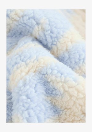 Šviesiai mėlynas ir grietinėlės spalvos pūkuotas flisinis audinys su tekstūruotu, minkštu paviršiumi, turintis gradientinį spalvų derinį.