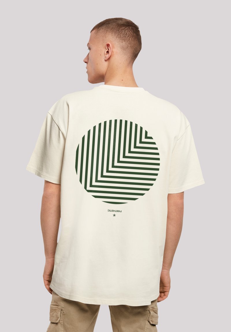Cream-colored t-shirt featuring a large circular graphic on the back, with green diagonal stripes and a small text detail at the bottom.