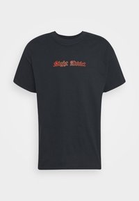 Svart bomulls t-shirt med kort ärm och rund halsringning. Har röd broderad text "Night Addict" i en dekorativ stil på bröstet.