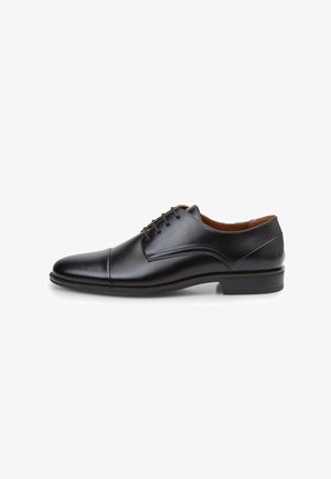 Scarpa da uomo in pelle nera con punta arrotondata, design con lacci, cuciture sottili e finitura liscia. Presenta un tacco basso e suola in gomma.