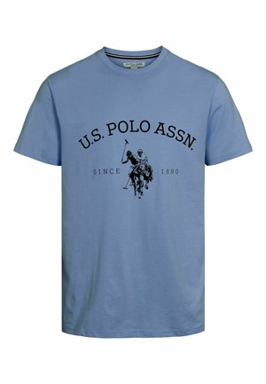 Lichtblauwe katoenen T-shirt met een ronde halslijn. Zwart bedrukt tekst "U.S. POLO ASSN." en een afbeelding van twee polo spelers met paarden.