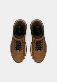 Brune lædersneakers med en struktureret finish, sorte snørebånd og en polstret krave. Har en kontrasterende gummisål og logo-detalje indeni.