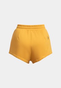 Gele katoenen shorts met een elastische tailleband, voorzien van zijzakken en een subtiele geborduurde logo aan de voorkant.