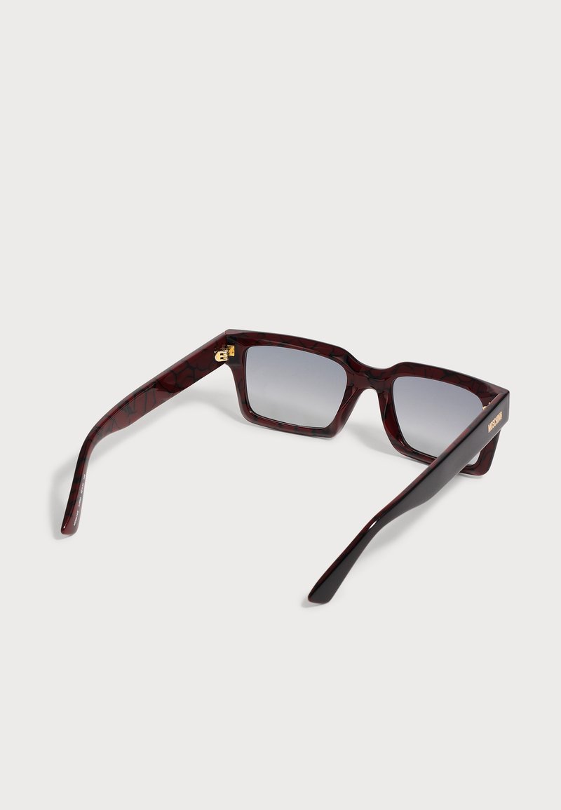 Dark red tortoiseshell rectangular sunglasses with gradient gray lenses and gold logo detail on the temples, shown from an angled rear view.