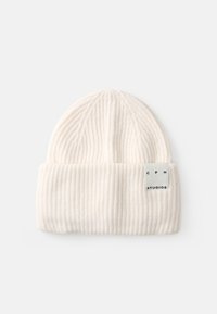 Pehmeast valgest lõngast kootud beanie, millel on sooniktekstuur. Patsil ainete disain ja ristkülikuline silt, millel on kiri "CPH STUDIOS."