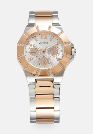 Silberne und roségoldene Metallarmbanduhr mit achteckiger Lünette, funkelnden Akzenten, drei Hilfszifferblättern und strukturiertem Zifferblatt.