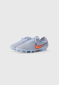 Light blue soccer cleats with ridged texture, black and orange swoosh logo, flat laces, and conical studs for traction.