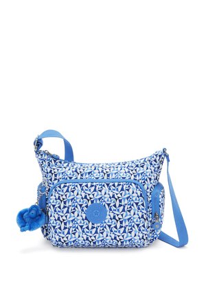 Blue patterned crossbody bag featuring a floral design, zippered pocket, and a textured blue pom-pom charm attached. Adjustable strap included.