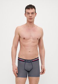 Boxers ajustés rayés navy avec un design cintré. Dotés d'une ceinture logo aux couleurs contrastées, d'un tissu lisse et d'un devant contourné.