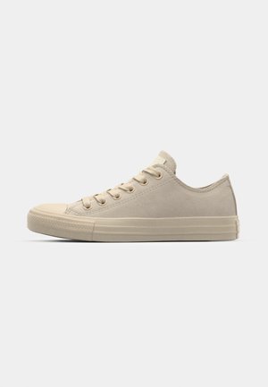 Beiga låga canvas sneakers med rund tå, snörning framtill och texturerad mocka yta. Har gummisula och minimala varumärkesdetaljer.
