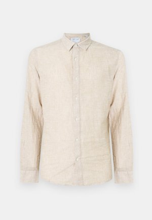 Chemise beige à manches longues en tissu texturé, avec un col classique, une fermeture à boutons et une coupe décontractée.