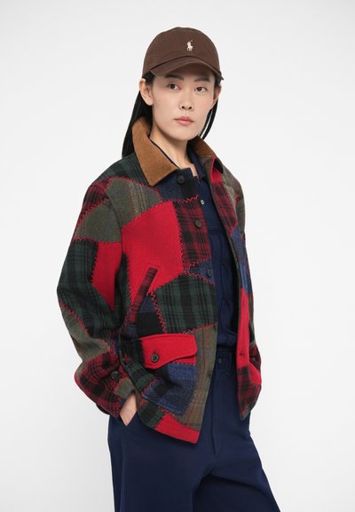 Μπουφάν πατςγουορκ με καρό μοτίβα σε κόκκινο, πράσινο και ναυτικό μπλε, με καφέ γιακά από κορντόροι και δύο τσέπες μπροστά, κλειστό με κουμπιά εμπρός.