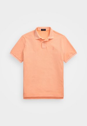 Polo orange en coton, avec un col, des manches courtes et un petit logo brodé sur la poitrine. Tissu doux, coupe classique.