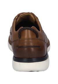 Braunes Leder-Schuh mit runder Zehenform, schwarz-weißer Sohle, strukturiertem Obermaterial und einem Schlaufen-Heeltab für einfaches Anziehen.