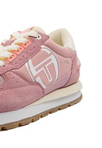 Sneaker in suede e tessuto rosa con accenti e logo bianchi. Presenta una suola imbottita, rete testurizzata e dettagli dei lacci a contrasto.