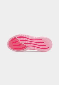 Semelle d'une basket rose avec des rainures texturées et des lignes d'adhérence rose plus foncé, présentée sur un fond blanc uni.