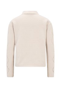 Ljusbeige stickad tröja med krage och långa ärmar, med zick-zack utskärningsdetaljer längs ärmsluten och en strukturerad yta.