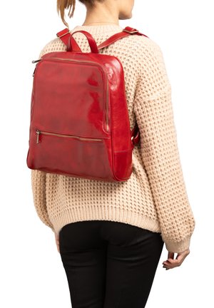 Zaino in pelle rossa con finitura liscia, dotato di tasca frontale con zip, spallacci regolabili e forma rettangolare.