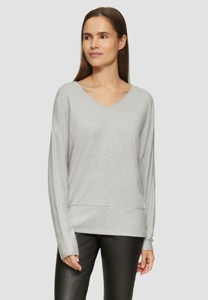 Lichtgrijze, lang mouw V-hals top met een losse pasvorm en een gelaagd voorontwerp, gemaakt van zachte stof, in combinatie met zwarte broek.