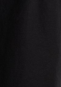 Gros plan d'un tissu noir lisse avec une texture tissée subtile et des plis légers visibles.