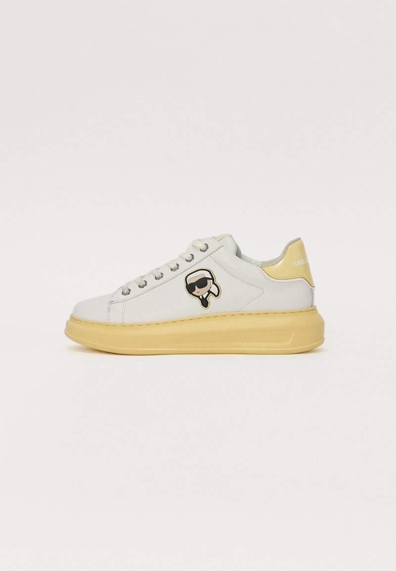 Weiße Ledersneaker mit gelbem Sohle, die ein verspieltes grafisches Akzent aufweisen. Runde Zehenpartie, Schnürdesign und gepolsterter Kragen.