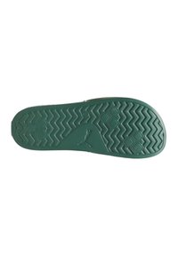 Semelle de chaussure en caoutchouc verte présentant un motif en zigzag et des accents hexagonaux. Comprend un logo et des zones texturées pour une meilleure adhérence.
