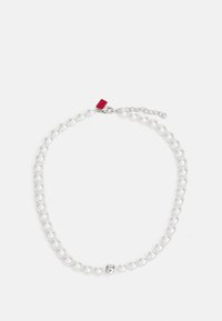 Witte parelketting met een zilveren sluiting en een decoratieve kraal. Bevat uniforme ronde parels en een klein rood label eraan bevestigd.