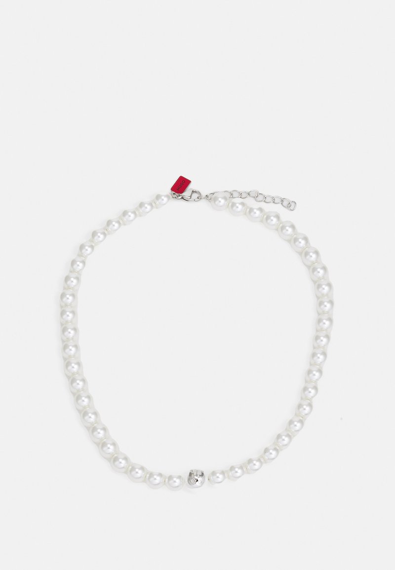 Witte parelketting met een zilveren sluiting en een decoratieve kraal. Bevat uniforme ronde parels en een klein rood label eraan bevestigd.