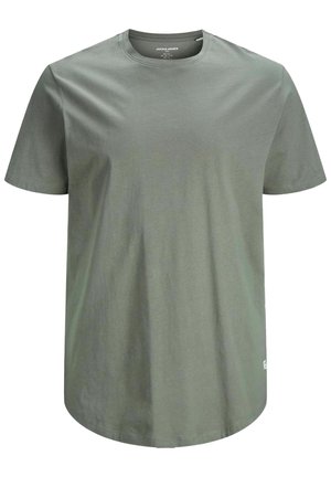 Homme portant un t-shirt ajusté à manches courtes gris clair uni et un pantalon noir, debout, les bras détendus le long du corps.