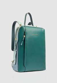 Zaino in pelle turchese con accenti azzurri, dettagli in oro, forma strutturata, doppi manici superiori e spallacci regolabili.