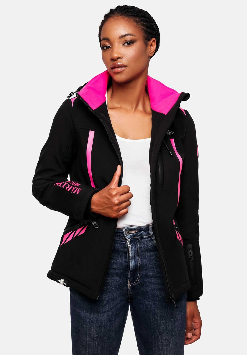 Woman wearing a black jacket with bright pink accents, unzipped over a white top and blue jeans, holding the jacket near the chest.