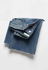 Jean en denim bleu foncé avec un ourlet effiloché, fermeture à bouton et poches. Le tissu a une texture en sergé classique.