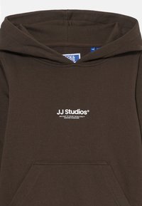 Felpa con cappuccio marrone realizzata in tessuto morbido, dotata di tasca a marsupio e logo bianco "JJ Studios" sul petto.