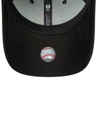 Black cap with a flat brim, featuring a circular MLB sticker with a baseball design centered on the brim. Textured fabric with stitching details.