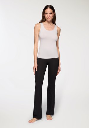 Top in cotone grigio chiaro a maniche corte con scollo a barca, abbinato a pantaloni neri a campana. Entrambi i capi sono realizzati in un tessuto liscio e elasticizzato.