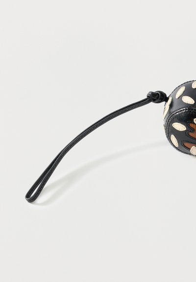 Μαύρο δερμάτινο λουράκι καρπού προσαρτημένο σε στρογγυλό μαύρο χάντρα αξεσουάρ με λευκά και καφέ ραμμένα σχέδια.